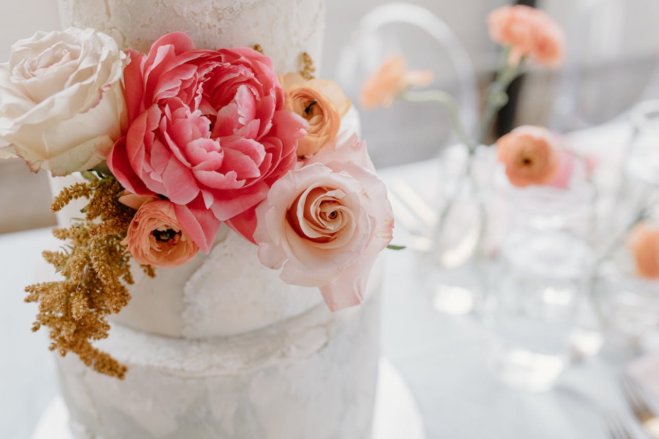 our-services-2 A beautifully decorated wedding cake adorned with pink and white roses and peonies, perfect for a romantic celebration.